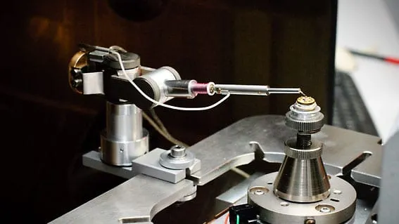 SEM image of a tungsten probe tip machined to a point with a rectangular window cut near its base, mounted for the RoTip rotational axis.